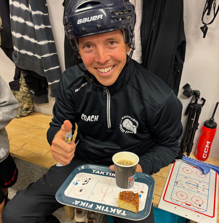 Glad tränare ritar upp taktik på fikabrickan.