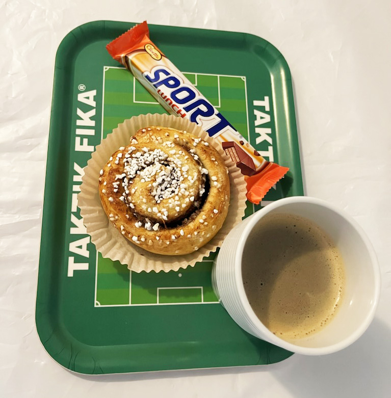 Glad tränare ritar upp taktik på fikabrickan.